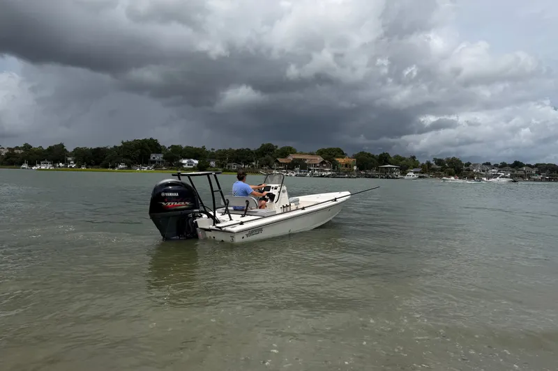 Slide: The Image of 2020 Hewes Redfisher 18 boat on water under cloudy sky, near shoreline. - 5