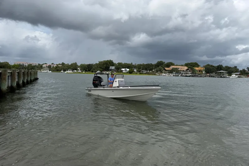 Slide: The Image of 2020 Hewes Redfisher 18 boat on a calm lake under cloudy skies. - 10