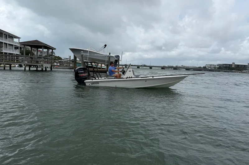 Slide: The Image of 2020 Hewes Redfisher 18 boat on water near docks under cloudy sky. - 9