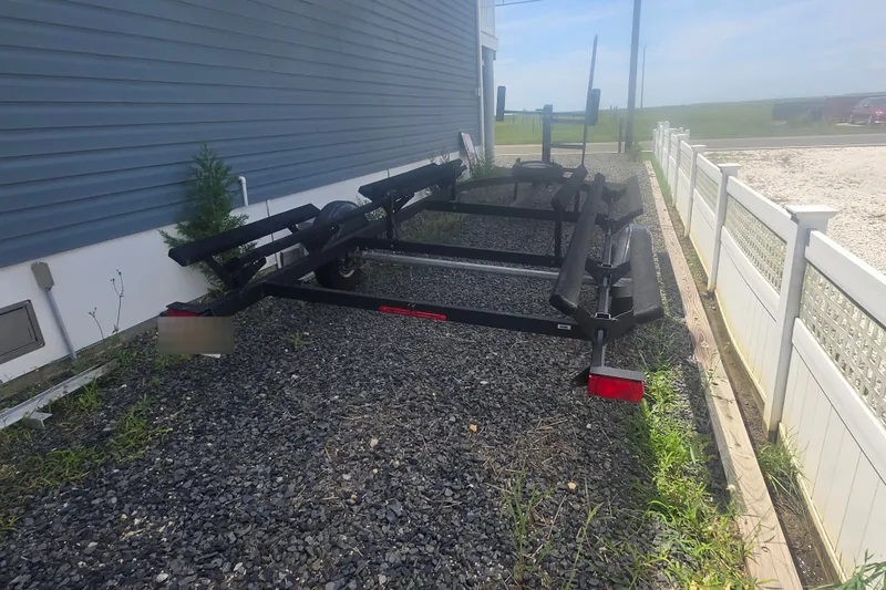 Slide: The Image of Trailer for 2024 Sun Tracker Bass Buggy 16 XL Select on gravel beside house. - 31