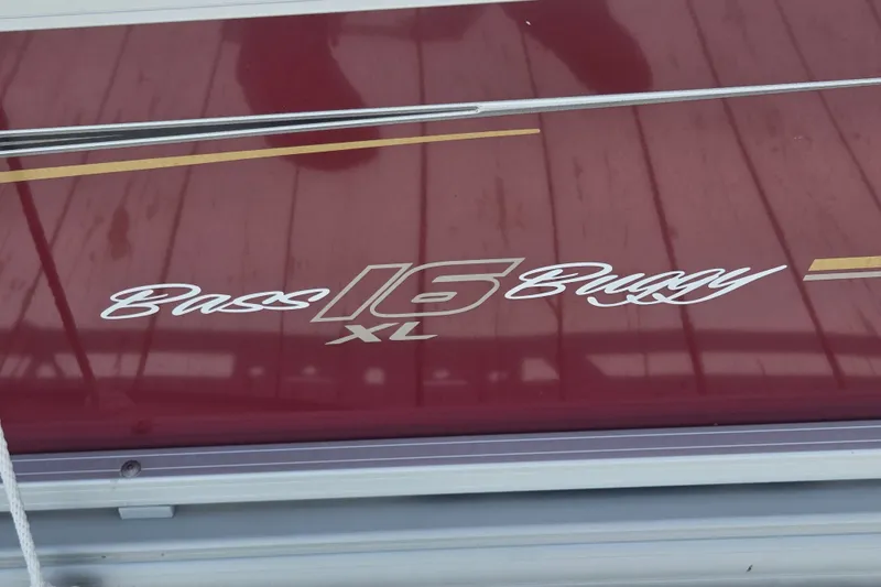 Slide: The Image of 2024 Sun Tracker Bass Buggy 16 XL Select logo on maroon surface. - 22