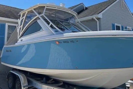 The Image of 2023 Sailfish 245 DC boat on trailer, parked near a house. - 0