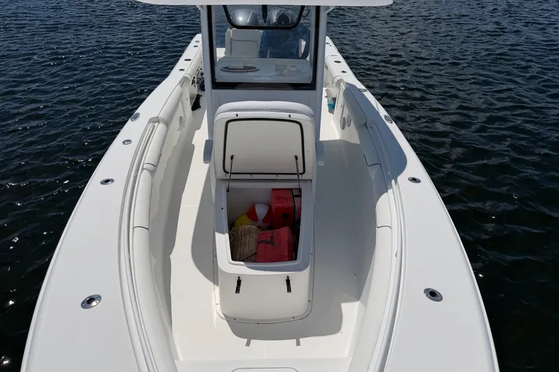 Slide: The Image of 2019 Sea Hunt Gamefish 30 boat with open storage compartment on calm water. - 23