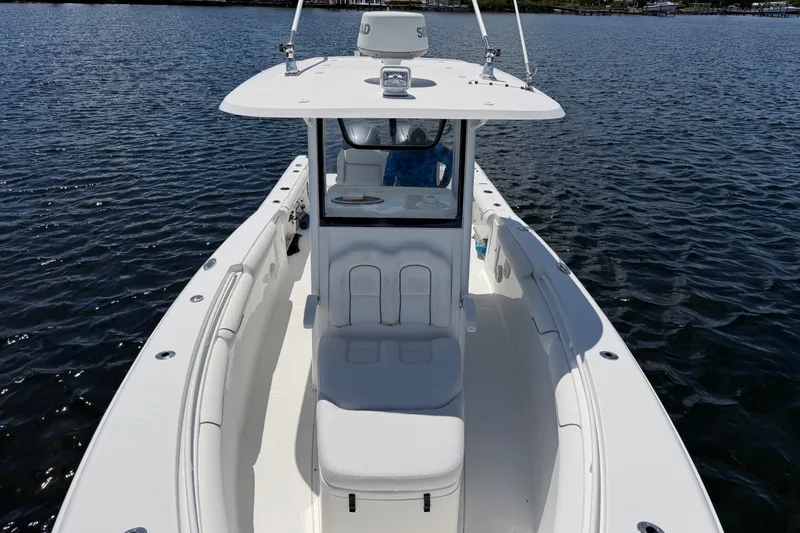 Slide: The Image of 2019 Sea Hunt Gamefish 30 boat on calm water, showcasing sleek design and spacious deck. - 20