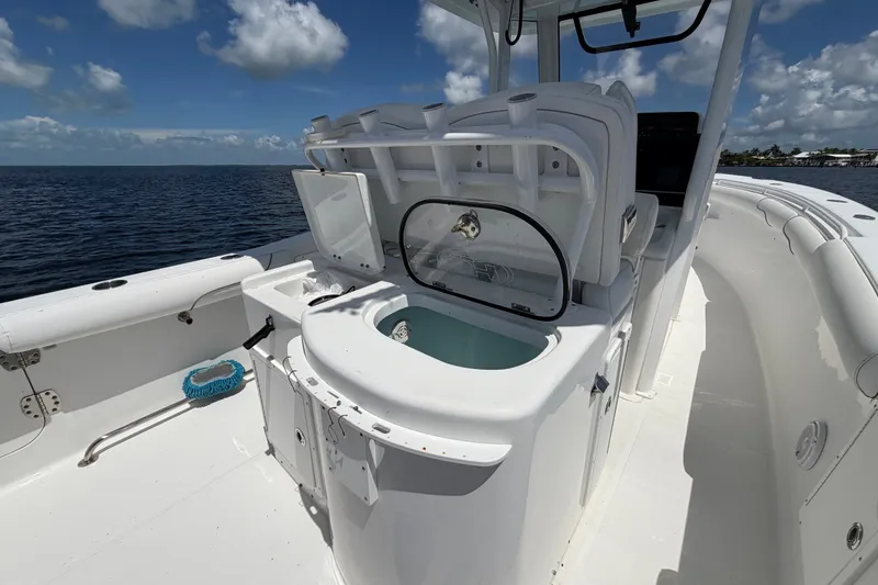 Slide: The Image of 2019 Sea Hunt Gamefish 30 boat interior with fishing amenities, under a clear blue sky. - 17