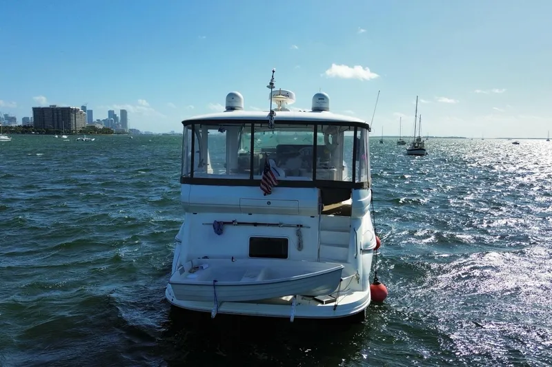 Slide: The Image of 2003 Sea Ray 480 Motor Yacht on water with city skyline in background. - 58
