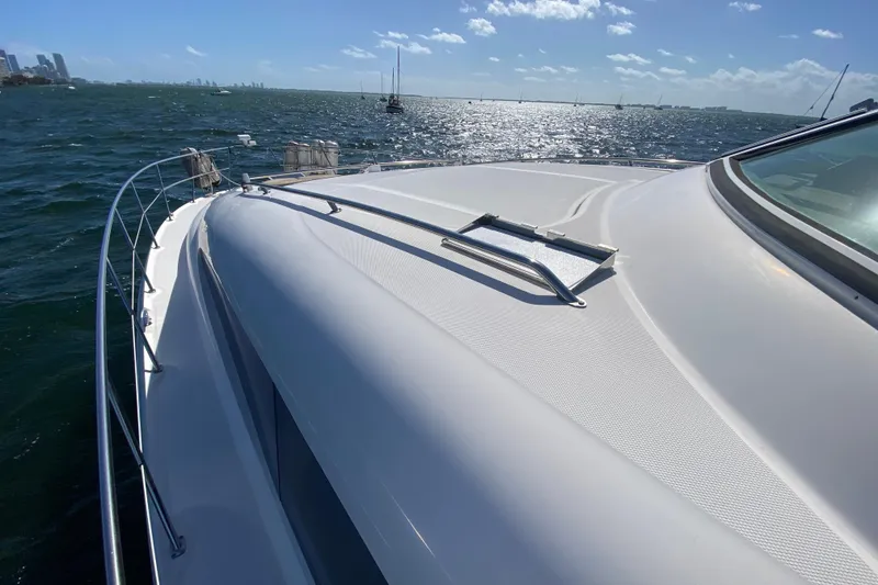 Slide: The Image of 2003 Sea Ray 480 Motor Yacht cruising on a sunny day, city skyline in background. - 25