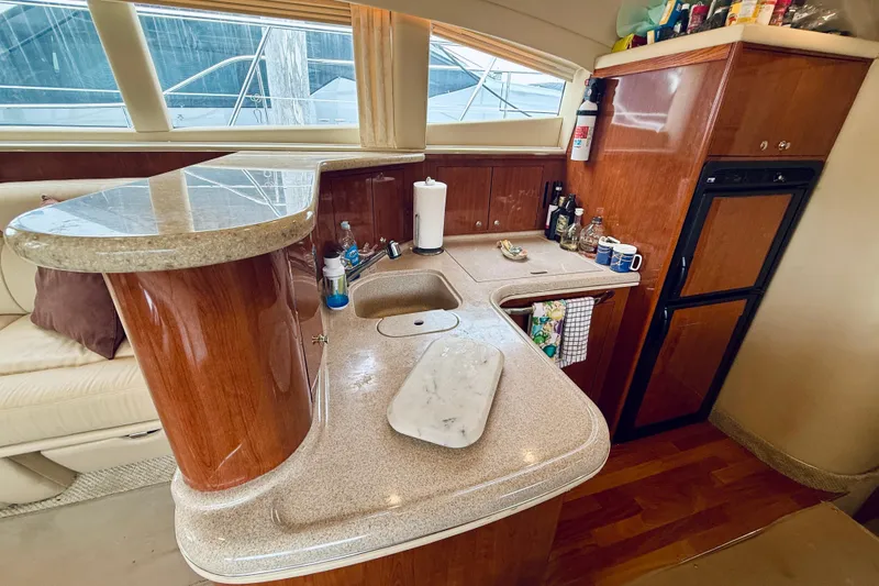 Slide: The Image of Luxurious 2003 Sea Ray 480 Motor Yacht interior with elegant kitchen and wooden cabinetry. - 44