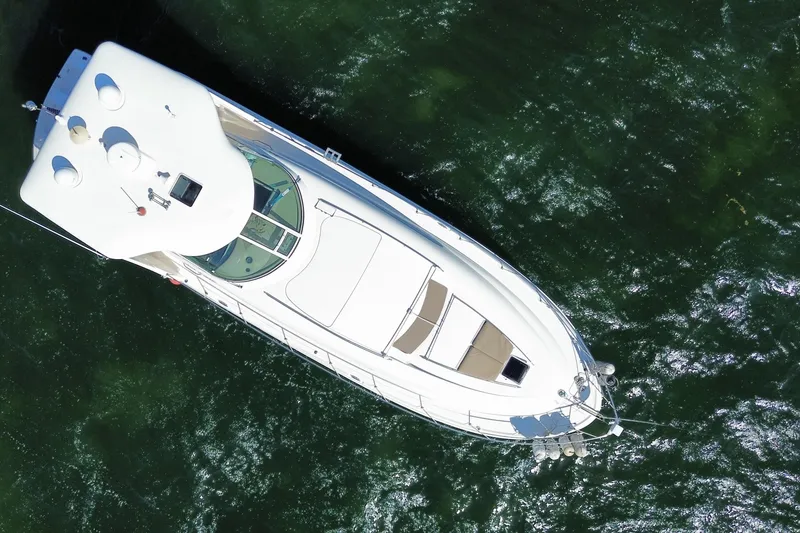 Slide: The Image of Aerial view of 2003 Sea Ray 480 Motor Yacht on green water. - 62