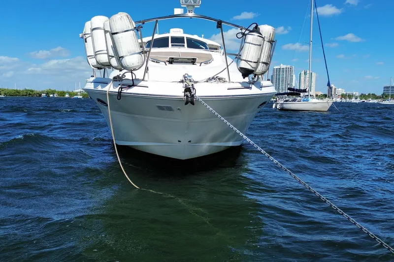Slide: The Image of 2003 Sea Ray 480 Motor Yacht anchored on a sunny day with city skyline backdrop. - 18