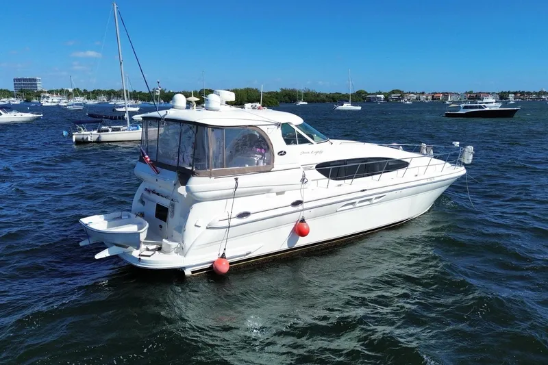 Slide: The Image of 2003 Sea Ray 480 Motor Yacht on water, surrounded by other boats under clear blue sky. - 57