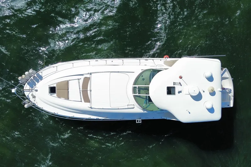 Slide: The Image of Aerial view of 2003 Sea Ray 480 Motor Yacht on green water. - 61