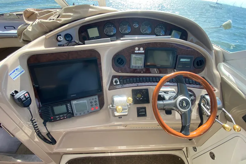 Slide: The Image of 2003 Sea Ray 480 Motor Yacht helm with navigation instruments and wooden steering wheel. - 35