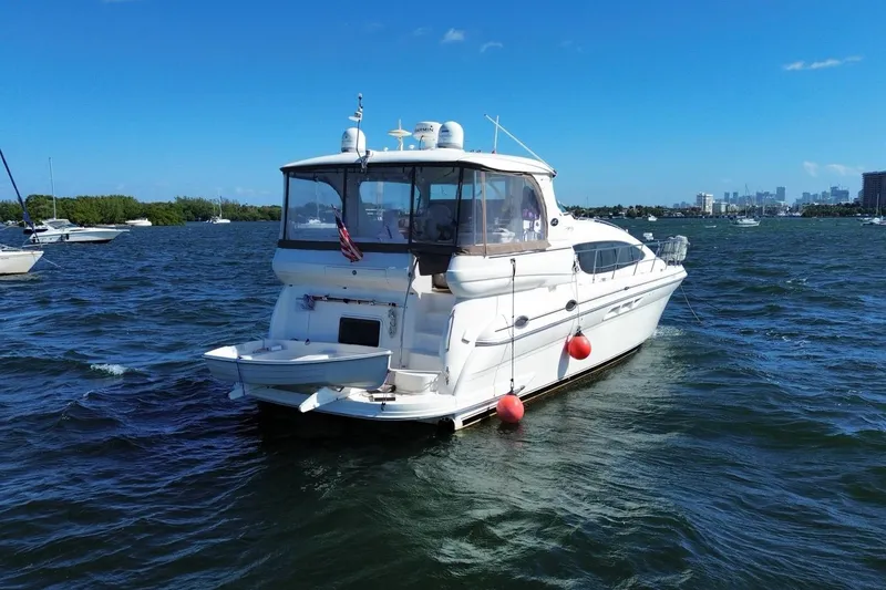 Slide: The Image of 2003 Sea Ray 480 Motor Yacht on water, clear sky, city skyline in background. - 56