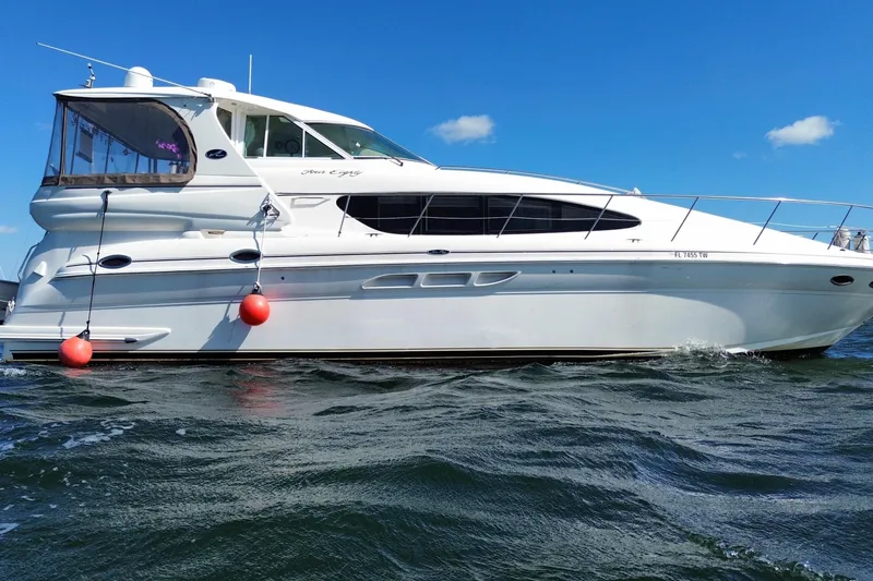 Slide: The Image of 2003 Sea Ray 480 Motor Yacht cruising on open water under clear blue sky. - 21