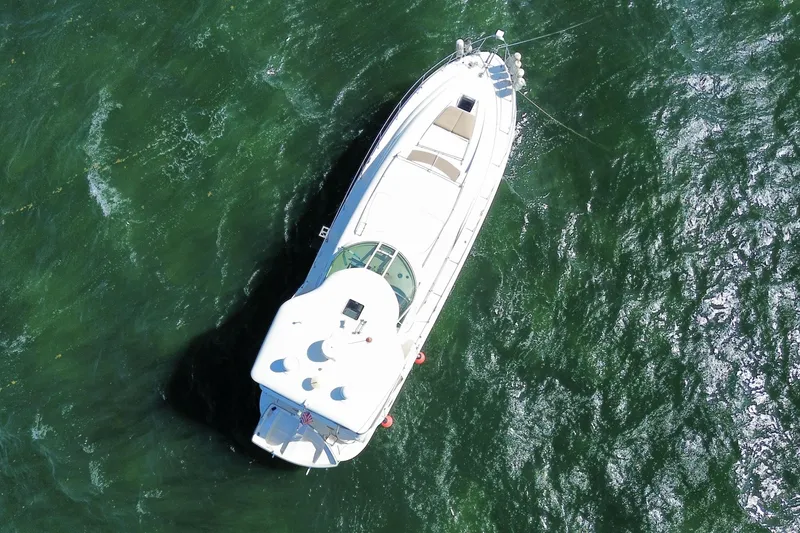 Slide: The Image of Aerial view of 2003 Sea Ray 480 Motor Yacht on green water. - 59