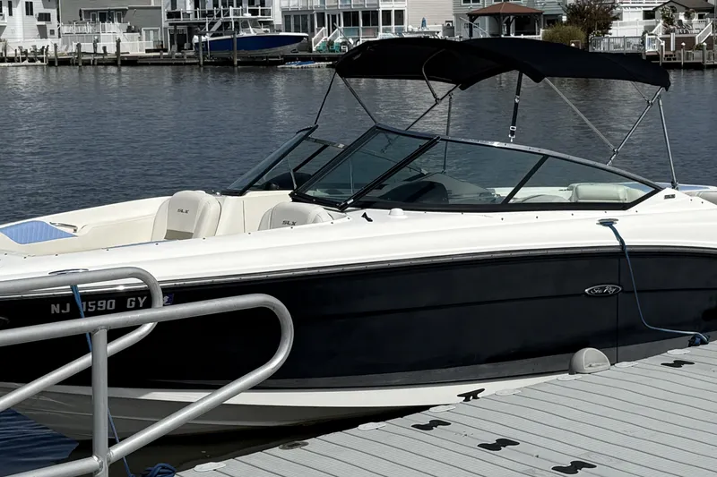 Slide: The Image of 2006 Sea Ray 270 SLX boat docked at marina, featuring sleek design and black hull. - 6