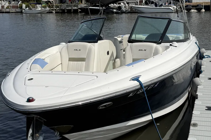 The Image of 2006 Sea Ray 270 SLX boat docked on calm water, featuring sleek design and spacious seating. - 0