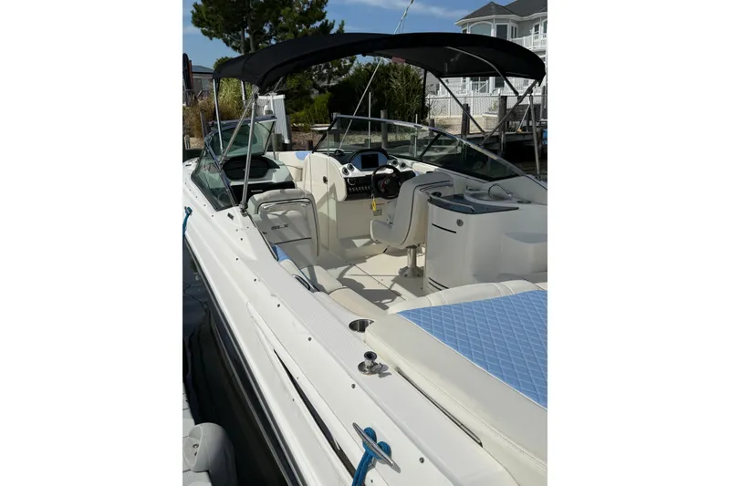 Slide: The Image of 2006 Sea Ray 270 SLX boat with canopy, docked near waterfront homes. - 9