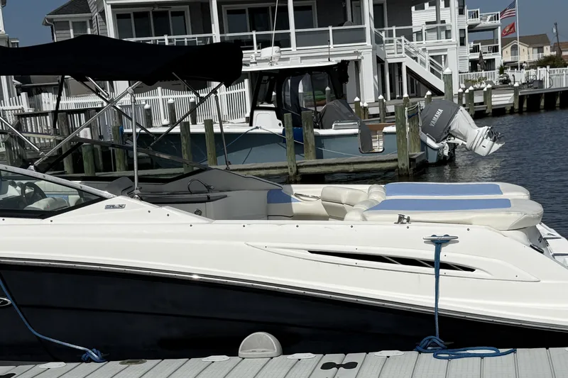 Slide: The Image of 2006 Sea Ray 270 SLX boat docked at a marina with waterfront homes. - 7