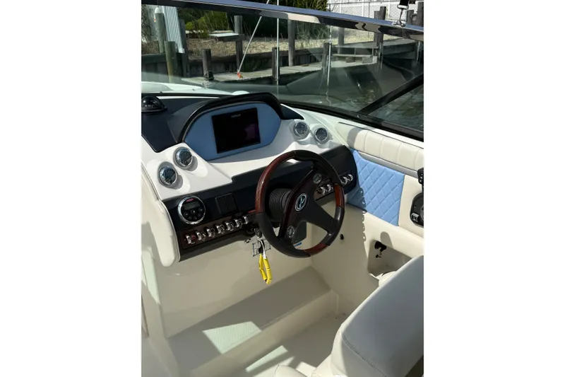 Slide: The Image of Interior view of 2006 Sea Ray 270 SLX boat cockpit with steering wheel and dashboard controls. - 2
