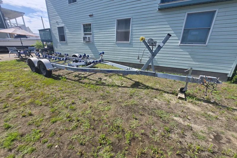 Slide: The Image of Trailer for 2014 Grady-White Fisherman 230 boat parked beside a house. - 3