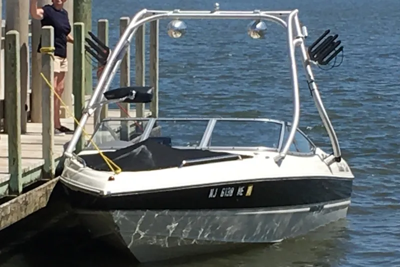 Slide: The Image of 2012 Stingray 195 LS/LX boat docked on a sunny day by the water. - 0