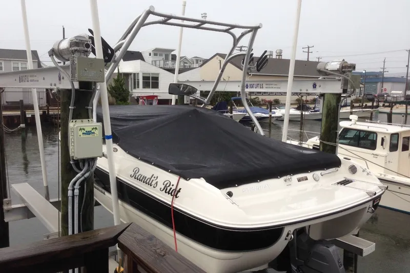 Slide: The Image of 2012 Stingray 195 LS/LX boat, covered and docked, with "Randi's Ride" text on the side. - 5