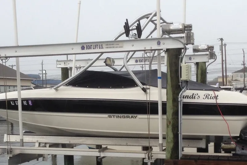 Slide: The Image of 2012 Stingray 195 LS/LX boat on lift, docked at marina. - 2