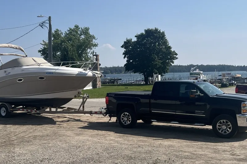 Slide: The Image of Black truck towing 2007 Four Winns 288 Vista boat near a lakeside marina. - 11