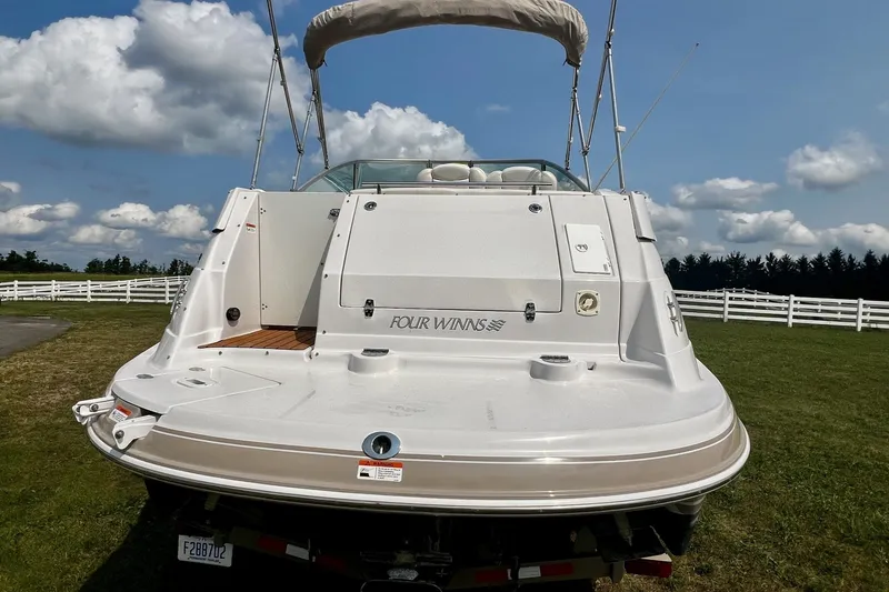 Slide: The Image of 2007 Four Winns 288 Vista boat on grass, showcasing rear deck and branding. - 6
