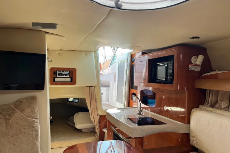 Slide: The Image of Interior of 2007 Four Winns 288 Vista boat with kitchenette, TV, and cozy sleeping area. - 17