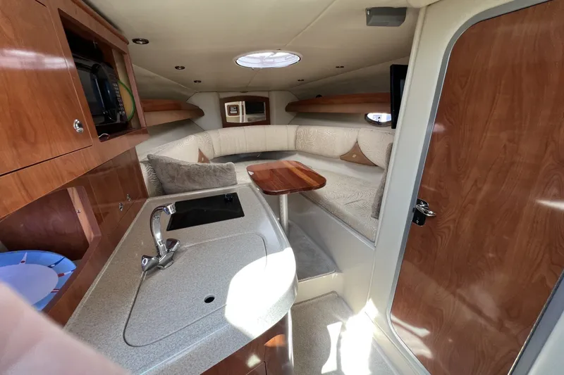 Slide: The Image of Luxurious 2007 Four Winns 288 Vista cabin interior with kitchenette and cozy seating area. - 20