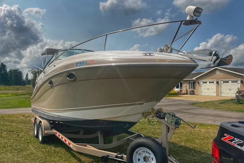 Slide: The Image of 2007 Four Winns 288 Vista boat on trailer, parked in residential driveway under cloudy sky. - 3