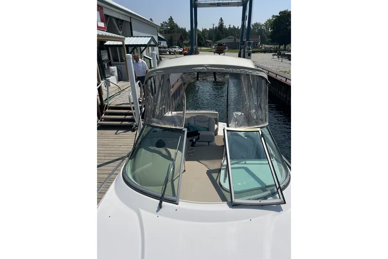 Slide: The Image of 2007 Four Winns 288 Vista boat docked, featuring open windshield and covered cockpit. - 22