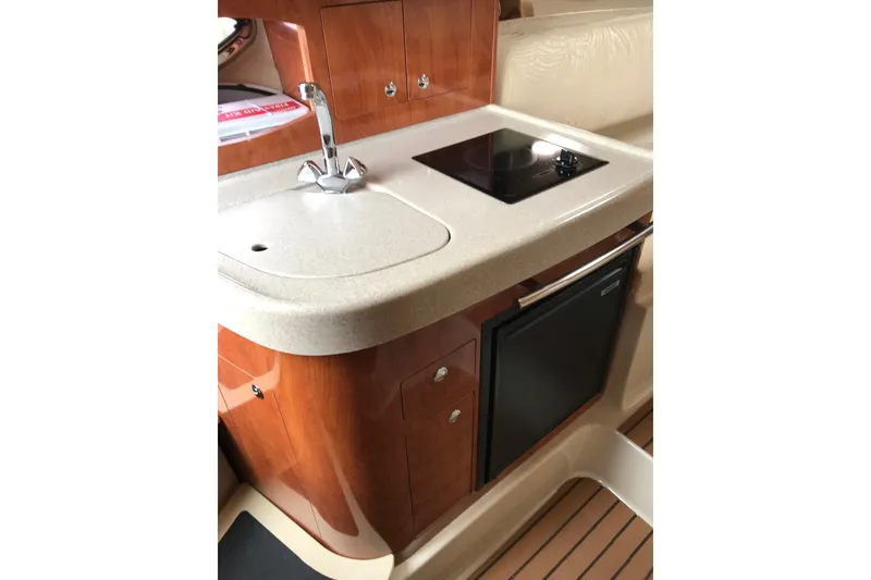 Slide: The Image of 2007 Four Winns 278 Vista boat interior kitchen with sink, stove, and wooden cabinetry. - 22