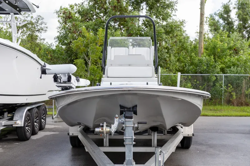 Slide: The Image of 2020 Shallow Sport 21 Sport boat on trailer, parked outdoors with greenery background. - 17