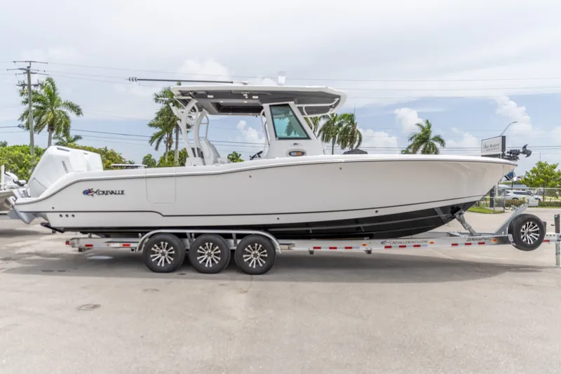 The Image of 2026 Crevalle 33 CSF boat on trailer, parked outdoors with palm trees in background. - 0