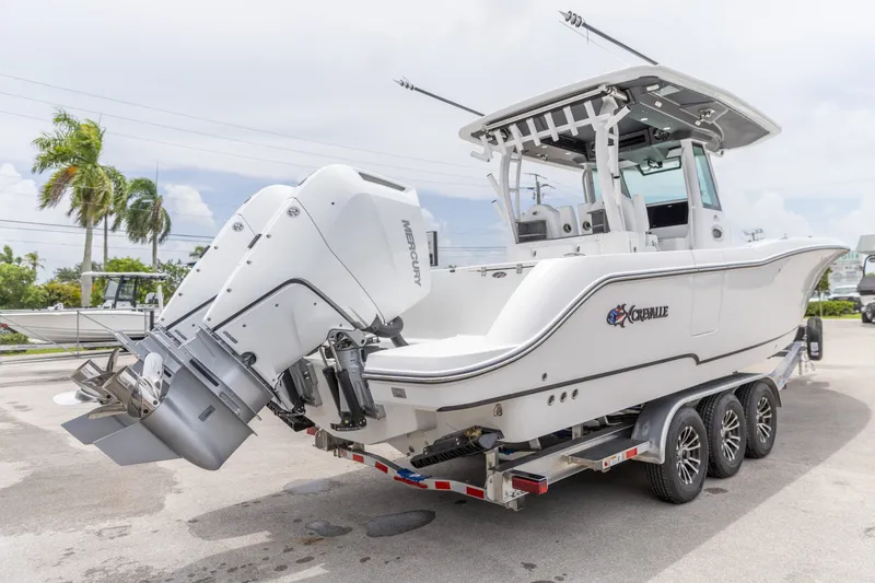 Slide: The Image of 2026 Crevalle 33 CSF boat on trailer with dual Mercury engines, parked outdoors. - 11