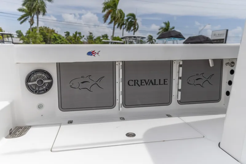 Slide: The Image of 2026 Crevalle 33 CSF boat interior with fish design and speaker, palm trees in background. - 17