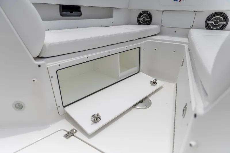 Slide: The Image of 2026 Crevalle 33 CSF boat interior storage compartment with white cushioned seating. - 32