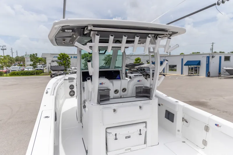Slide: The Image of 2026 Crevalle 33 CSF boat with rod holders and Yeti cooler, docked outdoors. - 5