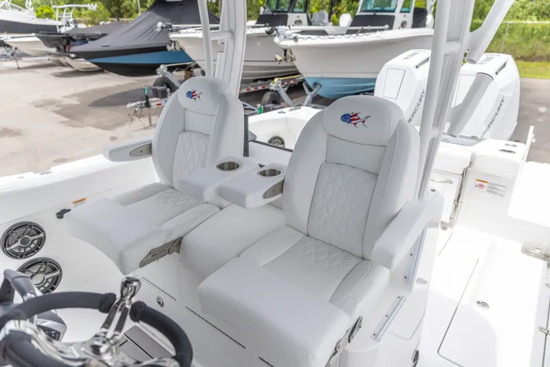 Slide: The Image of Luxury seating on 2026 Crevalle 33 CSF boat, featuring white leather and cup holders. - 24