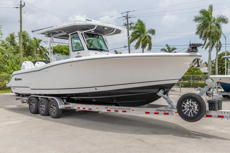 Slide: The Image of 2026 Crevalle 33 CSF boat on trailer, parked outdoors with palm trees in background. - 12