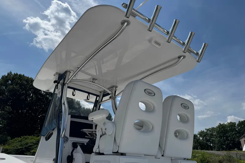 Slide: The Image of 2013 Southport 27 FE boat with T-top and dual white seats under a clear sky. - 24