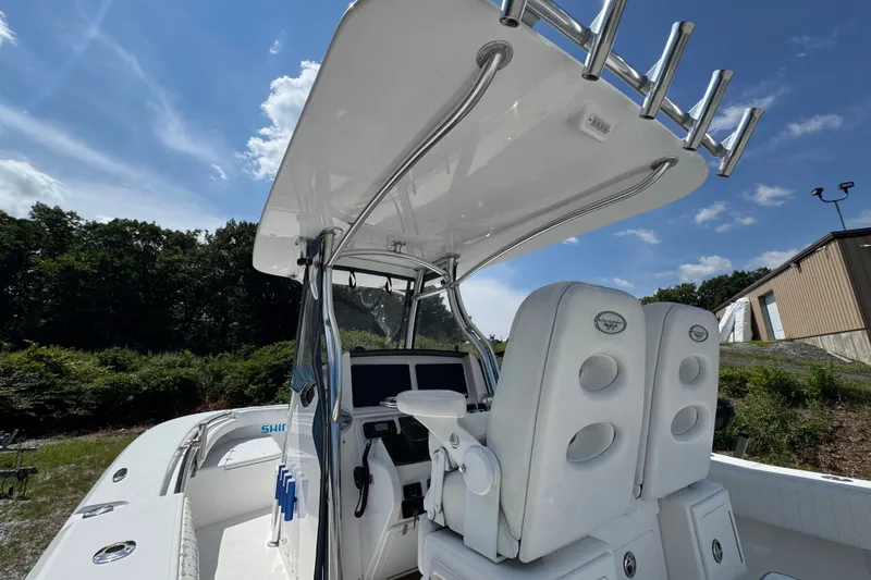Slide: The Image of 2013 Southport 27 FE boat interior with helm and seating under clear blue sky. - 25