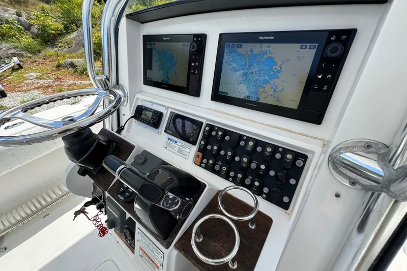 Slide: The Image of Control panel of a 2013 Southport 27 FE boat with navigation screens and steering wheel. - 15