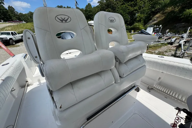 Slide: The Image of Dual captain's chairs on 2013 Southport 27 FE boat, featuring white upholstery and armrests. - 33