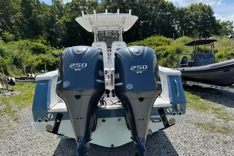 Slide: The Image of 2013 Southport 27 FE boat with twin Yamaha 250 V6 engines, parked outdoors. - 11