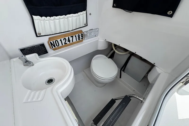 Slide: The Image of Interior of 2013 Southport 27 FE boat featuring a compact marine bathroom. - 31